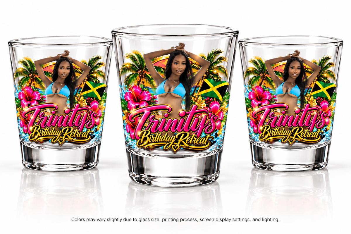 Three clear personalized shot glasses featuring a vibrant tropical Jamaica birthday retreat design with pink hibiscus flowers, palm trees, a Jamaican flag, a woman in blue, and pink-and-gold Trinity's Birthday Retreat lettering. Displayed on a white studio background.